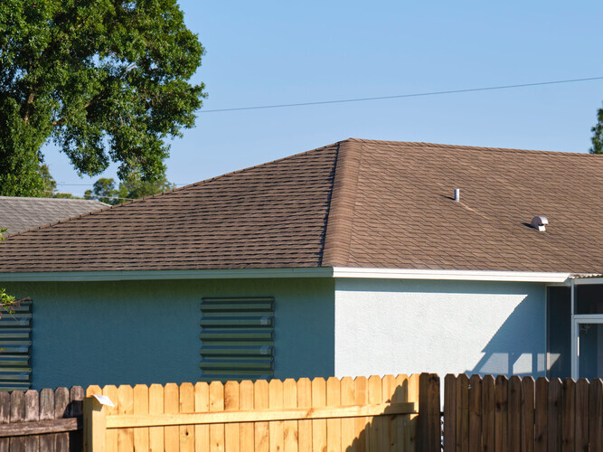 Closeup of house roof top covered with asphalt or bitumen shingles. Waterproofing of new building